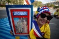 Thai woman with a photo of King Rama X and Queen Suthida