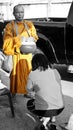 A Thai woman is praying at a monk`s feet in Bangkok