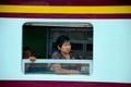 Thai woman rail passenger looks out of train carriage window Bangkok Thailand