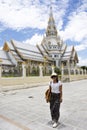 Thai woman standing posing for take photo with Ubosot of Wat Sothon Wararam Worawihan in Chachoengsao, Thailand