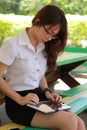 Thai woman student university beautiful girl using her tablet. Royalty Free Stock Photo