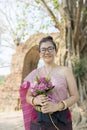 Thai woman toothy smiling face with pink lotus flower in hand Royalty Free Stock Photo