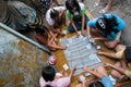 Thai women play money on cards in the slum of KLong Toey in Bangkok. Money games are prohibited in Thailand.