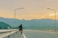 Thai women ride bicycle for exercise in the evening after sunset at Sriganarind Dam,