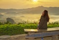 Thai women sit viewpoint beautiful sunshine at misty morning mountains ,Phulangka National Park, Payao Province,thailand