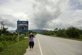 Thai women traveler posing for take photo with distance sign guide pole