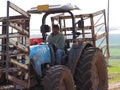 Thai worker works on an old tractor in Israeli fields