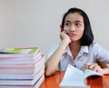 Thai young adult woman student in uniform reading a book Royalty Free Stock Photo