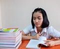 Thai young adult woman student in uniform reading a book Royalty Free Stock Photo