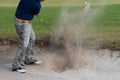 Thai young man golf player in action swing in sand pit during practice before golf tournament at golf course Royalty Free Stock Photo