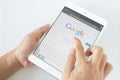 Thailand - April 6: Man hands are pointing on touch screen device with google serch.Google serch is top in serch engine in