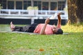 Lying on lawn in a city Park. A man reads a newspaper on the grass. The nature