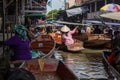Thailand, Bangkok - 06 November 2018: Tourists in traditional wooden boat buying goods on Damnoen Saduak Floating Market Royalty Free Stock Photo