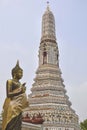 Buddha statue near the spire of a pagoda at the temple of dawn, wat arun Royalty Free Stock Photo