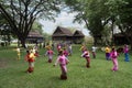 A teacher is teaching Thai dance to students in a Thai style house