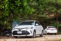 Two white cars Toyota Auris in the body of sedan under the green trees on the surin beach