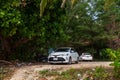 Two white cars Toyota Auris in the body of sedan under the green trees on the surin beach Royalty Free Stock Photo