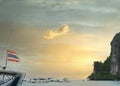 Thailand flag as the sunrises over the coast of the harbor,