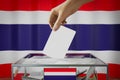 Thailand flag, hand dropping ballot card into a box - voting, election concept Royalty Free Stock Photo