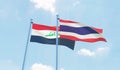 Thailand and Iraq, two flags waving against blue sky.