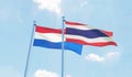 Thailand and Netherlands, two flags waving against blue sky. Royalty Free Stock Photo