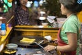 Thailand, Phuket July 5, 2019: Thai chef cooks Thai fast food pancakes in the evening on the street, turns a fried