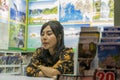 Thailand, Phuket, Patong, February 1, 2020: cute Thai woman, seller of tourist tours and tour packages, sitting bored in