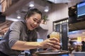 Thailand, Phuket, Patong. January 3, 2020: a smiling waitress serves a customer a glass with a cocktail and fruit juice. Good-