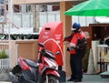 Thailand Post Officer unlocking the postbox to take the letter out with hygienic masked to prevent coronavirus or Covid 19