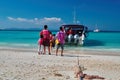 THAILAND, RACHA ISLAND, MARCH 23, 2018-people with children in lifejackets sit on a speedboat. Sunny tropical beach, turquoise sea