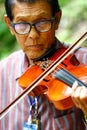 Thailand - September 10, 2017 An old man playing violin at the p Royalty Free Stock Photo