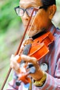 Thailand - September 10, 2017 An old man playing violin at the p Royalty Free Stock Photo