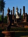 Statues of walking and sitting Buddha in Sukhothai Historical Park in Thailand Royalty Free Stock Photo