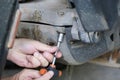 A man of Caucasian descent is fixing his malfunctioning motorbike.