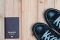 Thailand traveler`s Passport and sneakers ready to travel on wooden floor, top view with copy space, vacation concept