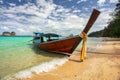 Thailand typical Long-tail boat on clear azure green sea, sky with small clouds above, golden beach on right, Koh Kradan Royalty Free Stock Photo