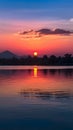 Thailands serene lake reflects vibrant hues of the setting sun