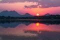 Thailands serene lake reflects vibrant hues of the setting sun