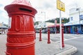 Low point of view of urban street with bright red traditional post box on corner