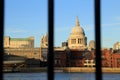 Thames river view with riverside buildings and st pauls cathedral dome look through blurred rail