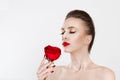 Beautiful moThan smell perfume aroma. Beautiful model woman smelling kissing red rose flower. Sexy red lipsdel woman kissing red Royalty Free Stock Photo