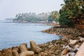 Thangassery Lighthouse cliff surrounded by palm trees and big sea waves on the Kollam beach. Kerala, India Royalty Free Stock Photo