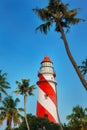 Thangassery Lighthouse on the cliff surrounded by palm trees and big sea waves on the Kollam beach. Kerala, India Royalty Free Stock Photo