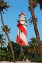 Thangassery Lighthouse on the cliff surrounded by palm trees and big sea waves on the Kollam beach. Kerala, India Royalty Free Stock Photo