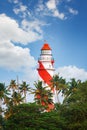 Thangassery Lighthouse on the cliff surrounded by palm trees and big sea waves on the Kollam beach. Kerala, India Royalty Free Stock Photo