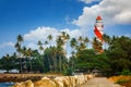Thangassery Lighthouse on the cliff surrounded by palm trees and big sea waves on the Kollam beach. Kerala, India Royalty Free Stock Photo