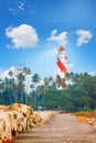 Thangassery Lighthouse on the cliff surrounded by palm trees and big sea waves on the Kollam beach. Kerala, India Royalty Free Stock Photo