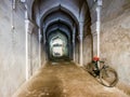 A bicycle parked in a long arcaded corridor inside the ancient Maratha Palace in