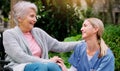 Thank you for all of your help. a cheerful elderly woman in a wheelchair spending time with her daughter outside in a Royalty Free Stock Photo