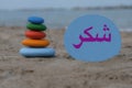 Thank you in arabic language with a creative stones composition on the beach Royalty Free Stock Photo